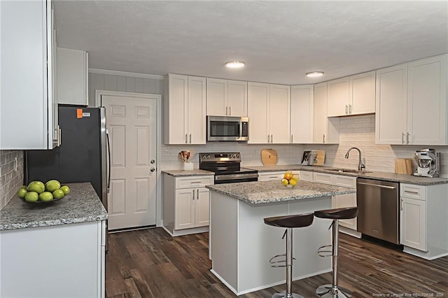 2110 Lombardy Dr, Fayetteville, NC 28304 - kitchen with appliances with stainless steel finishes, white cabinets, backsplash, and dark wood finished floors