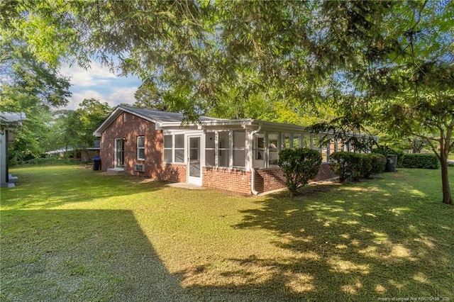 2110 Lombardy Dr, Fayetteville, NC 28304 - rear view of house featuring brick siding, a sunroom, and a yard