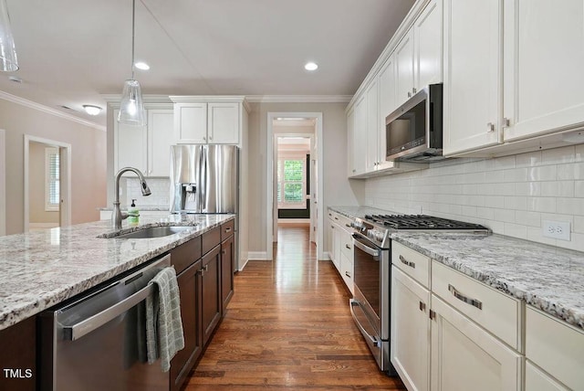 1962 Briar Chapel Pkwy, Chapel Hill, NC 27516 - kitchen with stainless steel appliances, ornamental molding, white cabinets, dark wood-style flooring, and light stone countertops