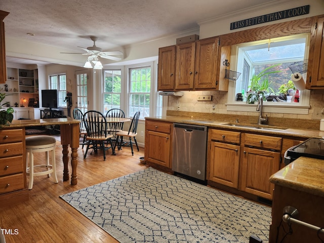 5760 Hesters Store Rd, Hurdle Mills, NC 27541 - kitchen with stainless steel dishwasher, light wood-style flooring, tasteful backsplash, a ceiling fan, and brown cabinets