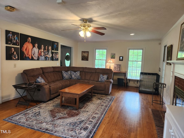5760 Hesters Store Rd, Hurdle Mills, NC 27541 - living room featuring a brick fireplace, wood finished floors, ornamental molding, a ceiling fan, and a textured ceiling