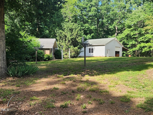 5760 Hesters Store Rd, Hurdle Mills, NC 27541 - view of grassy yard featuring a detached garage and an outbuilding
