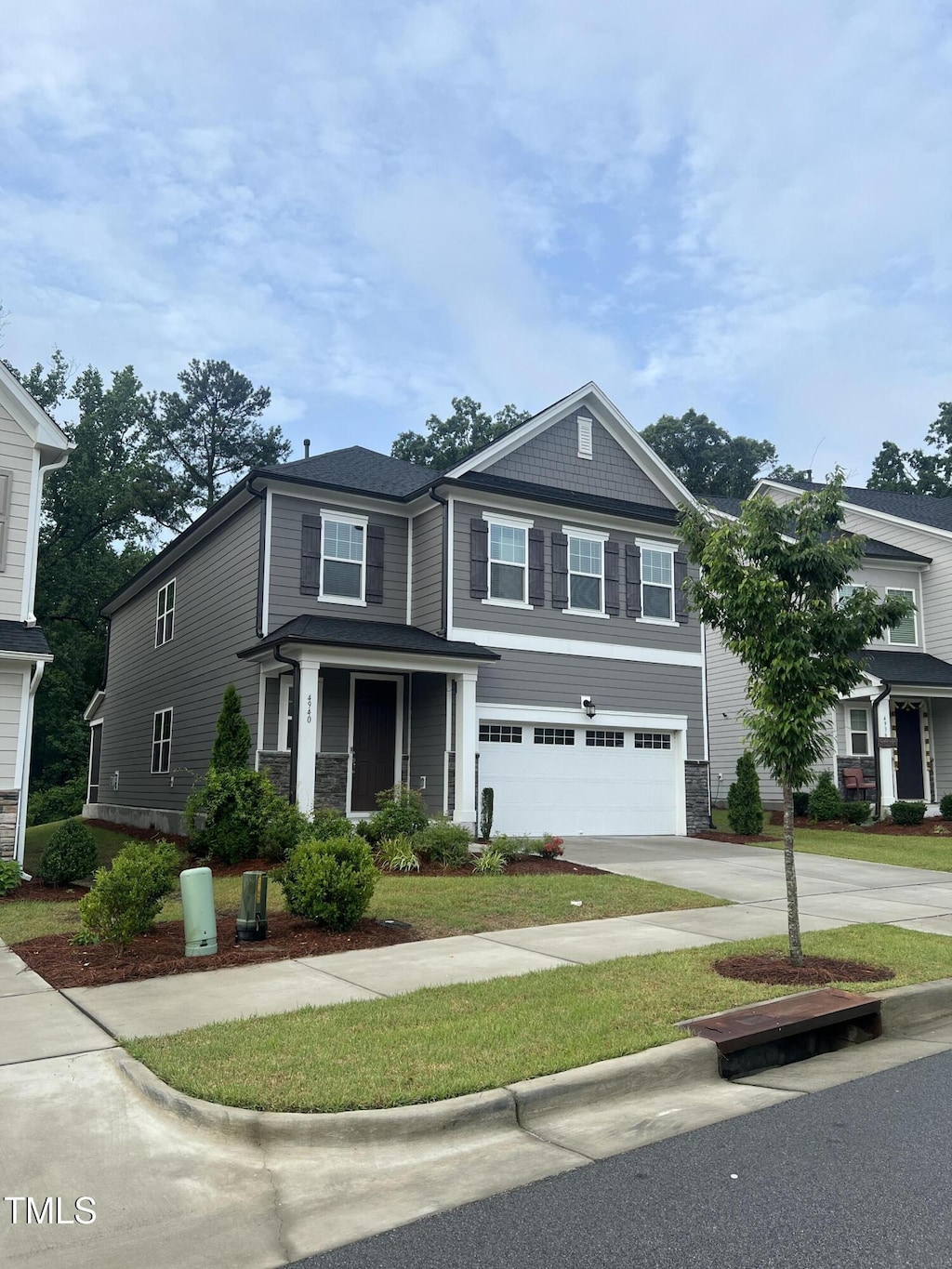 4940 Enlightenment Rd, Raleigh, NC 27616 - view of front of home with driveway, an attached garage, and stone siding