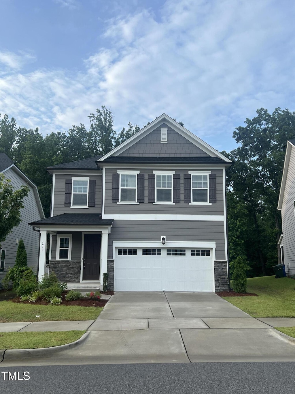 4940 Enlightenment Rd, Raleigh, NC 27616 - craftsman house with stone siding, a garage, driveway, and a front lawn