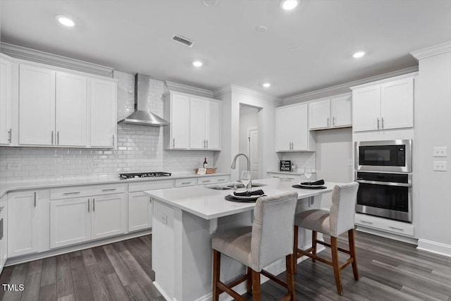 4940 Enlightenment Rd, Raleigh, NC 27616 - kitchen featuring stainless steel appliances, wall chimney exhaust hood, white cabinets, dark wood-style floors, and backsplash