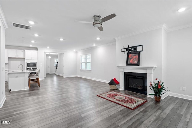 4940 Enlightenment Rd, Raleigh, NC 27616 - unfurnished living room with a ceiling fan, crown molding, recessed lighting, wood finished floors, and a fireplace