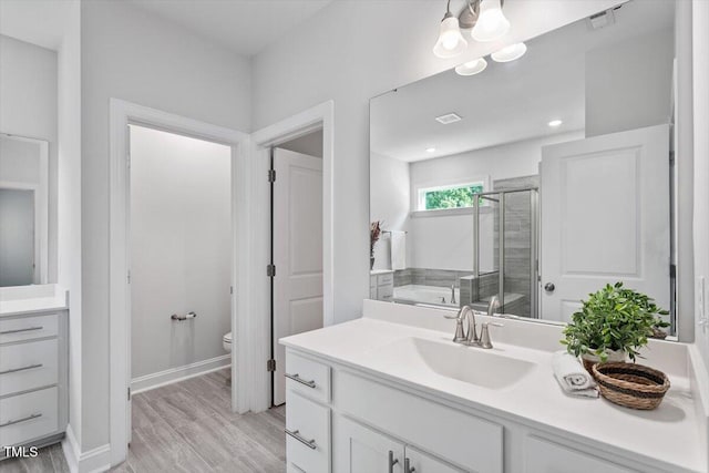 4940 Enlightenment Rd, Raleigh, NC 27616 - full bathroom with vanity, a stall shower, a bath, and wood finished floors