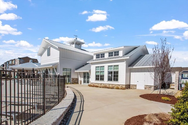4940 Enlightenment Rd, Raleigh, NC 27616 - back of property with a metal roof, stone siding, a standing seam roof, and concrete driveway