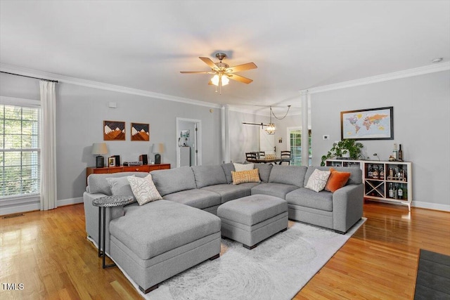 1819 Umstead Rd, Durham, NC 27712 - living room with light wood finished floors, a ceiling fan, ornamental molding, and a chandelier