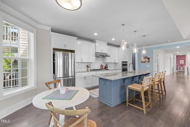 10310 Sablewood Dr Unit 211, Raleigh, NC 27617 - kitchen featuring stainless steel appliances, under cabinet range hood, a center island with sink, white cabinetry, and recessed lighting