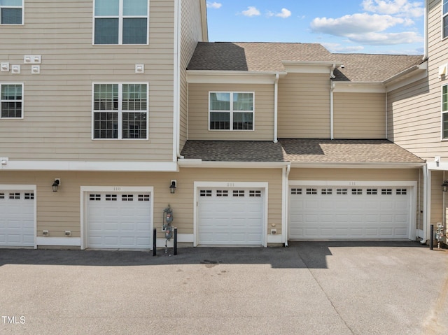 10310 Sablewood Dr Unit 211, Raleigh, NC 27617 - back of property featuring a garage, driveway, and a shingled roof