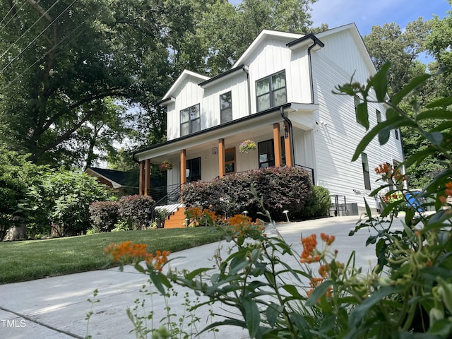 517 Bart St, Raleigh, NC 27610 - view of front facade featuring covered porch, board and batten siding, and a front yard