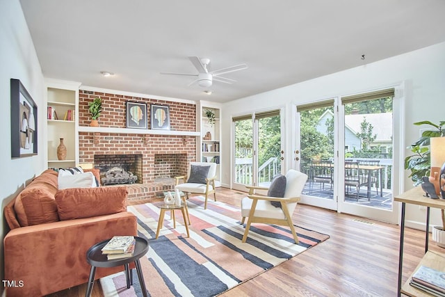 2334 Dawn Trl, Durham, NC 27712 - living area featuring built in features, wood finished floors, a ceiling fan, and a fireplace
