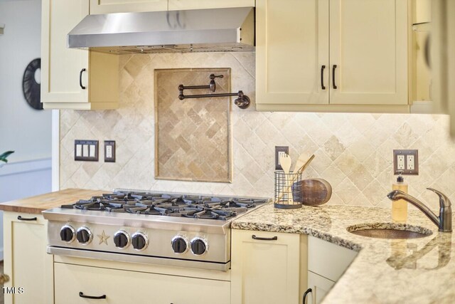2334 Dawn Trl, Durham, NC 27712 - kitchen with exhaust hood, stainless steel gas stovetop, backsplash, and light stone counters