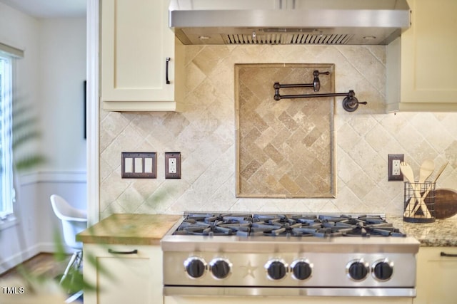 2334 Dawn Trl, Durham, NC 27712 - kitchen featuring under cabinet range hood, stove, tasteful backsplash, and light stone counters