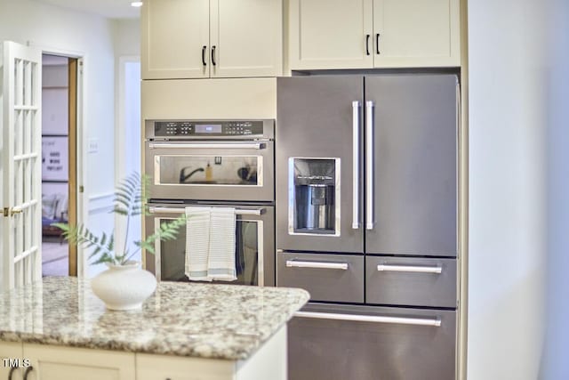 2334 Dawn Trl, Durham, NC 27712 - kitchen featuring appliances with stainless steel finishes, light stone countertops, and white cabinetry
