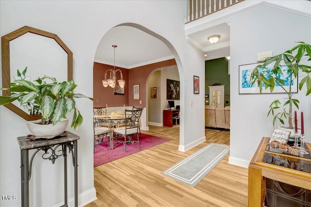 218 Kinvara Ct, Wake Forest, NC 27587 - foyer featuring light wood-type flooring, arched walkways, crown molding, a high ceiling, and a chandelier