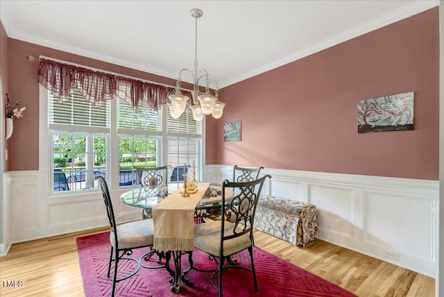 218 Kinvara Ct, Wake Forest, NC 27587 - dining room with wood finished floors, a decorative wall, a wainscoted wall, a chandelier, and crown molding
