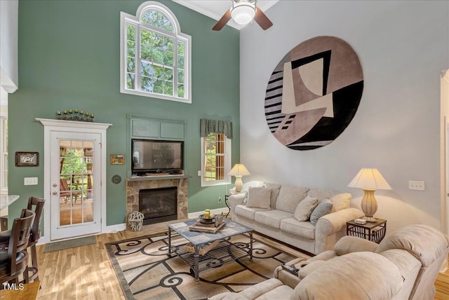 218 Kinvara Ct, Wake Forest, NC 27587 - living room with a glass covered fireplace, ceiling fan, wood finished floors, healthy amount of natural light, and a high ceiling