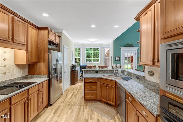 218 Kinvara Ct, Wake Forest, NC 27587 - kitchen featuring appliances with stainless steel finishes, light wood-style flooring, brown cabinets, stone counters, and ornamental molding