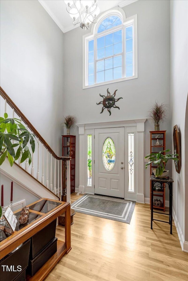 218 Kinvara Ct, Wake Forest, NC 27587 - foyer with stairway, wood finished floors, a chandelier, ornamental molding, and a high ceiling