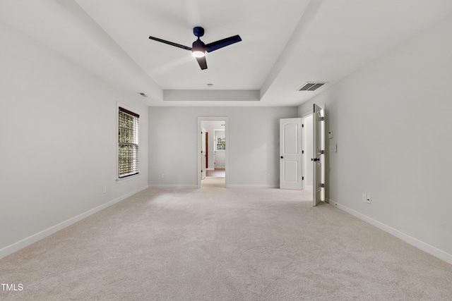109 Aspenridge Dr, Holly Springs, NC 27540 - unfurnished bedroom with a tray ceiling, light colored carpet, and a ceiling fan