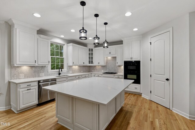 109 Aspenridge Dr, Holly Springs, NC 27540 - kitchen with black appliances, a center island, white cabinets, and recessed lighting