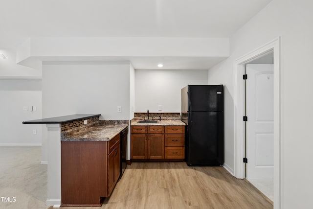 109 Aspenridge Dr, Holly Springs, NC 27540 - kitchen with black appliances, a peninsula, light wood finished floors, brown cabinets, and recessed lighting