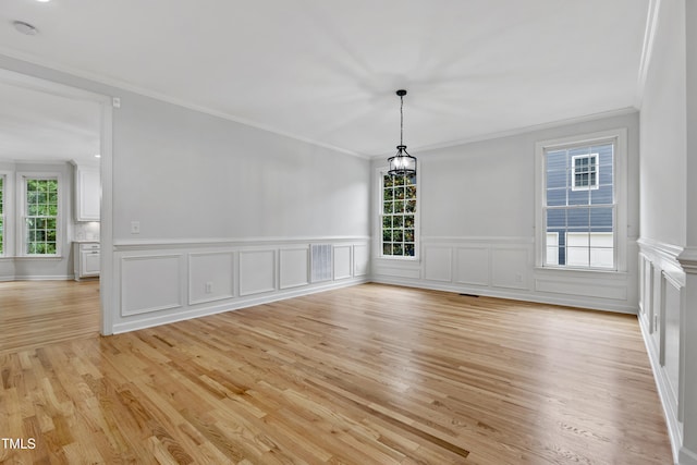 109 Aspenridge Dr, Holly Springs, NC 27540 - unfurnished dining area with ornamental molding, light wood-style floors, wainscoting, and a decorative wall