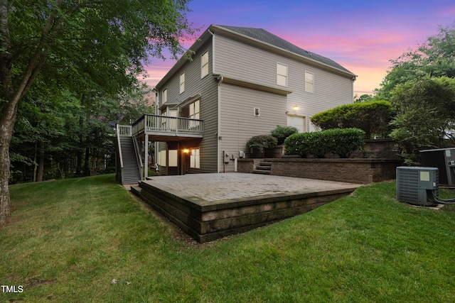 109 Aspenridge Dr, Holly Springs, NC 27540 - back of property at dusk with stairs, a deck, and a yard