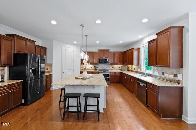 101 Ironcreek Pl, Apex, NC 27539 - kitchen featuring dishwashing machine, black fridge with ice dispenser, stainless steel stove, a kitchen bar, and wood finished floors