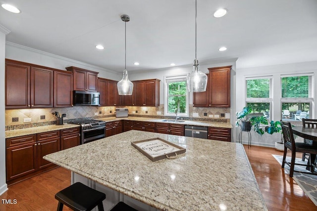 101 Ironcreek Pl, Apex, NC 27539 - kitchen featuring stainless steel appliances, a kitchen bar, dark wood finished floors, light stone counters, and tasteful backsplash