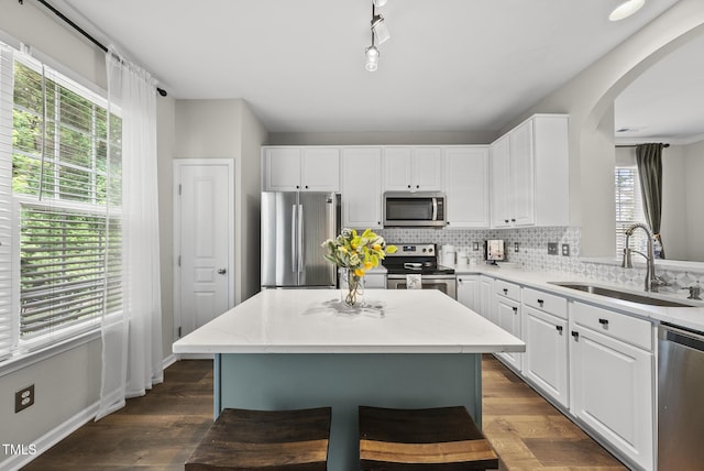 4413 Sugarbend Way, Raleigh, NC 27606 - kitchen featuring stainless steel appliances, arched walkways, tasteful backsplash, and white cabinetry
