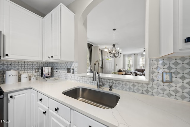 4413 Sugarbend Way, Raleigh, NC 27606 - kitchen featuring white cabinetry, tasteful backsplash, and arched walkways