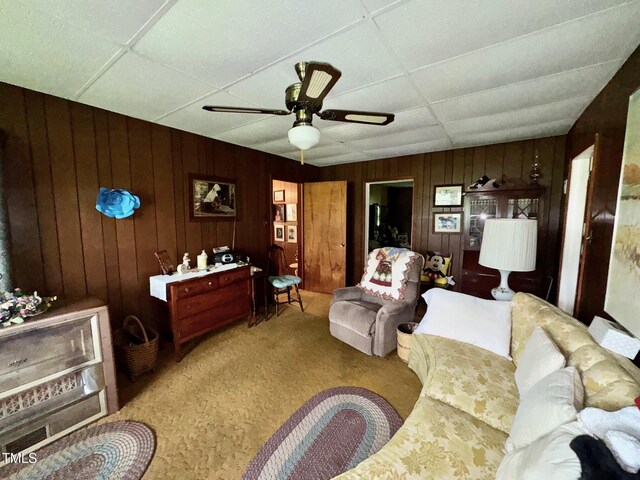 410 High St, Norlina, NC 27563 - living area with carpet floors, wood walls, a ceiling fan, and a drop ceiling