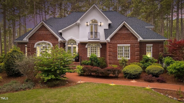 5 Wake Forest Ct, Southern Pines, NC 28387 - view of front of home with brick siding, a balcony, a front lawn, and a shingled roof