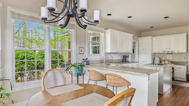 5 Wake Forest Ct, Southern Pines, NC 28387 - kitchen with a chandelier, dark wood finished floors, a peninsula, white cabinetry, and light stone counters