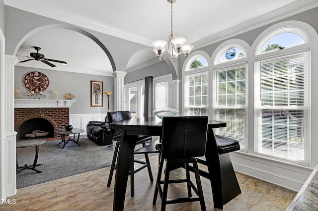 5013 Wheatridge Dr, Fuquay Varina, NC 27526 - dining room featuring arched walkways, ornamental molding, ceiling fan, a brick fireplace, and wainscoting