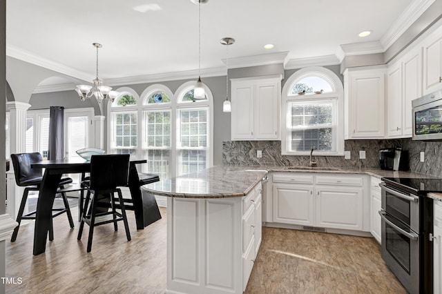5013 Wheatridge Dr, Fuquay Varina, NC 27526 - kitchen with stainless steel appliances, white cabinets, ornamental molding, decorative light fixtures, and recessed lighting