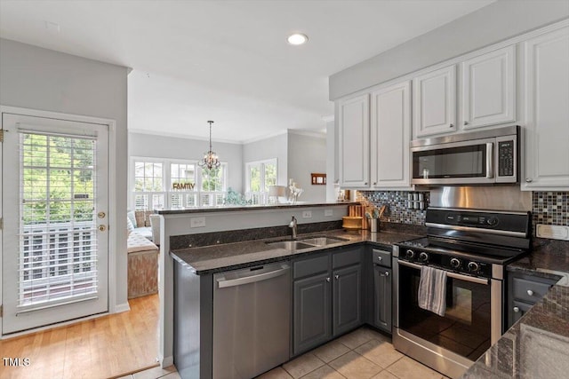 500 Weaver Mine Trl, Chapel Hill, NC 27517 - kitchen with appliances with stainless steel finishes, a peninsula, white cabinetry, healthy amount of natural light, and ornamental molding
