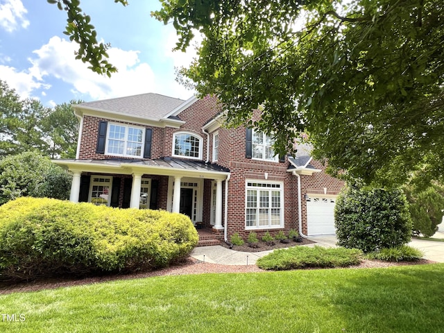 315 Birdwood Ct, Cary, NC 27519 - colonial home featuring brick siding, covered porch, a front yard, and an attached garage