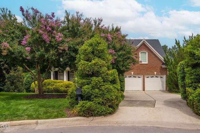 315 Birdwood Ct, Cary, NC 27519 - view of property hidden behind natural elements with driveway, brick siding, and a front yard