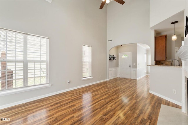 1016 Goldmist Ln, Durham, NC 27713 - unfurnished living room with ceiling fan, a high ceiling, wood finished floors, and arched walkways