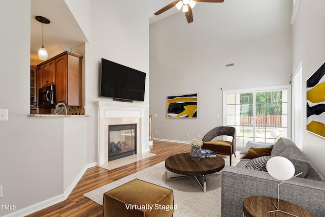 1016 Goldmist Ln, Durham, NC 27713 - living area with wood finished floors, a ceiling fan, a towering ceiling, and a fireplace