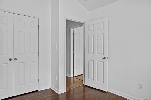 3118 High Plains Dr, Hope Mills, NC 28348 - unfurnished bedroom with dark wood-type flooring, lofted ceiling, and a closet