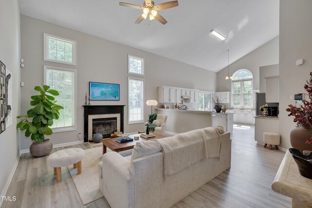 5308 Bentgrass Dr, Raleigh, NC 27610 - living area with high vaulted ceiling, light wood-type flooring, a high end fireplace, and plenty of natural light
