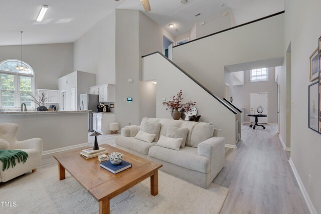 5308 Bentgrass Dr, Raleigh, NC 27610 - living area with high vaulted ceiling, light wood finished floors, stairs, and a chandelier