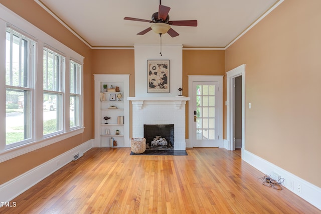 601 E Franklin St, Raleigh, NC 27604 - unfurnished living room featuring light wood-style flooring, a fireplace, crown molding, and a ceiling fan