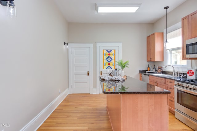 601 E Franklin St, Raleigh, NC 27604 - kitchen with appliances with stainless steel finishes, light wood-type flooring, a center island, pendant lighting, and dark stone counters