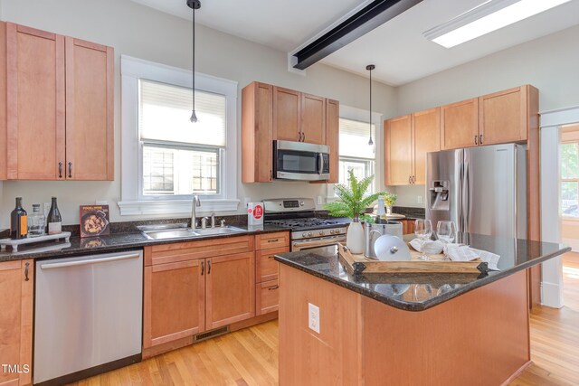 601 E Franklin St, Raleigh, NC 27604 - kitchen featuring stainless steel appliances, light wood-type flooring, decorative light fixtures, dark stone countertops, and a center island